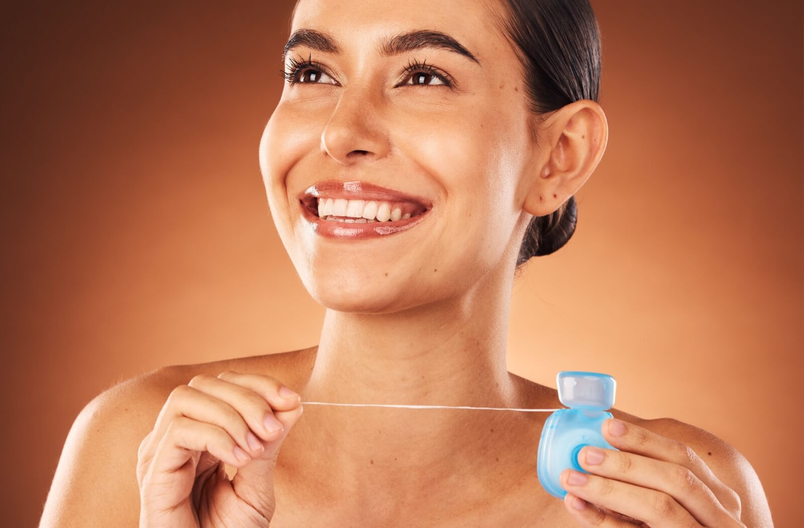 A close up of a person smiling, holding a toothbrush, about to brush their teeth.