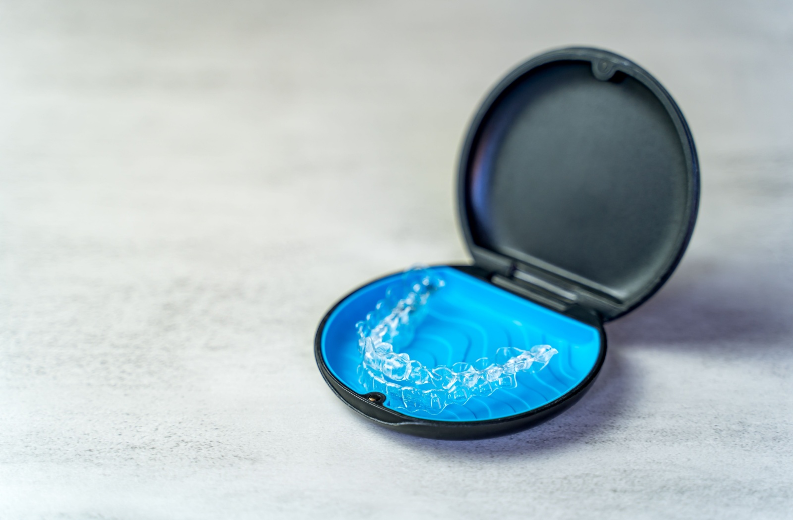 An image of a clear aligner in its storage case.