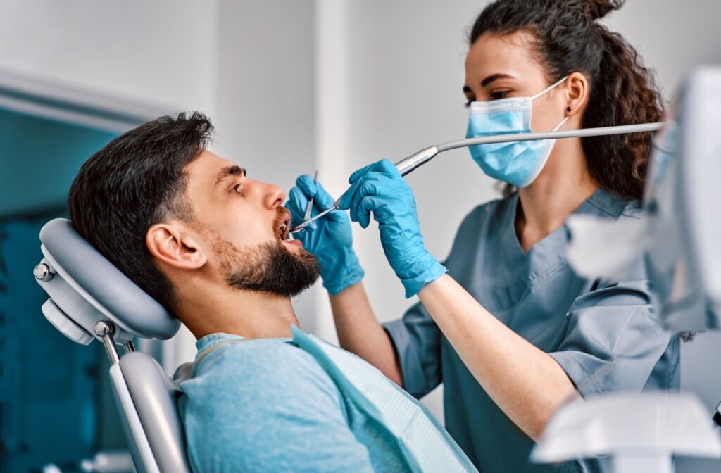 A dental hygienist thoroughly cleans their patient's teeth.