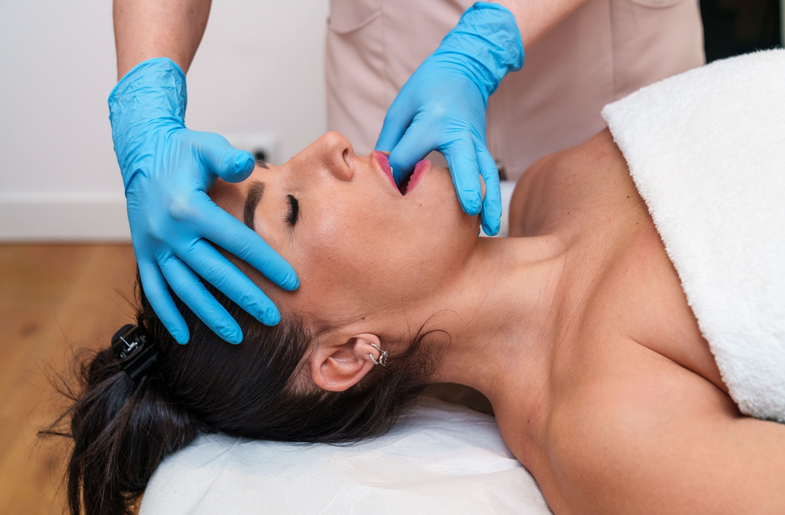 A person getting a TMJ massage due to chronic TMJ pain